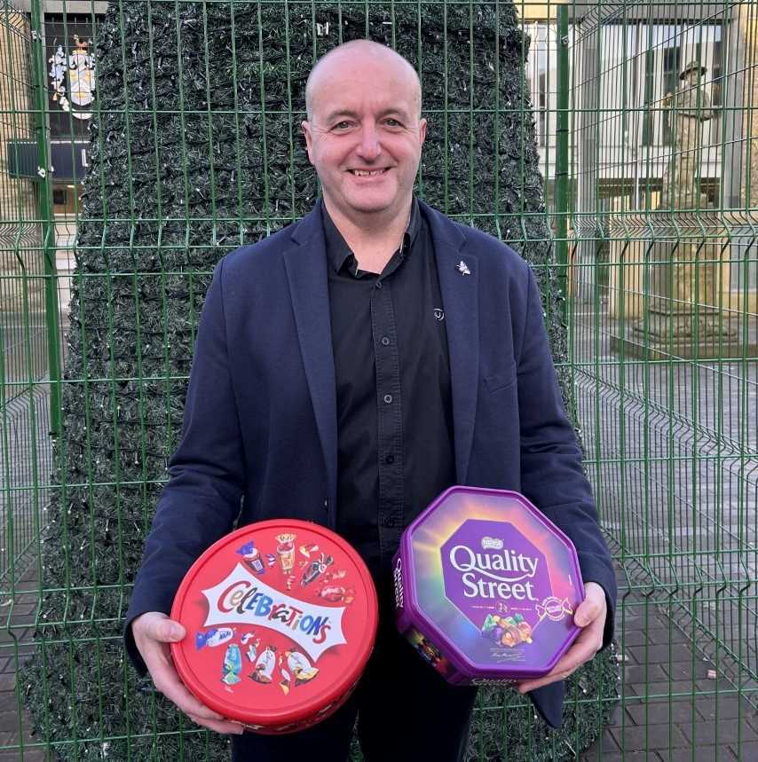 Photo of David Walker with examples of chocolate tubs which can be recycled