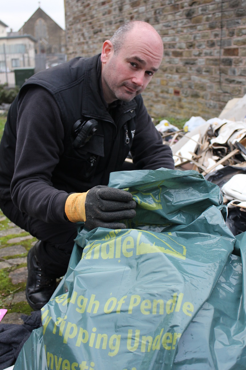 Photo showing Environmental Crime Officer investigating fly tipping