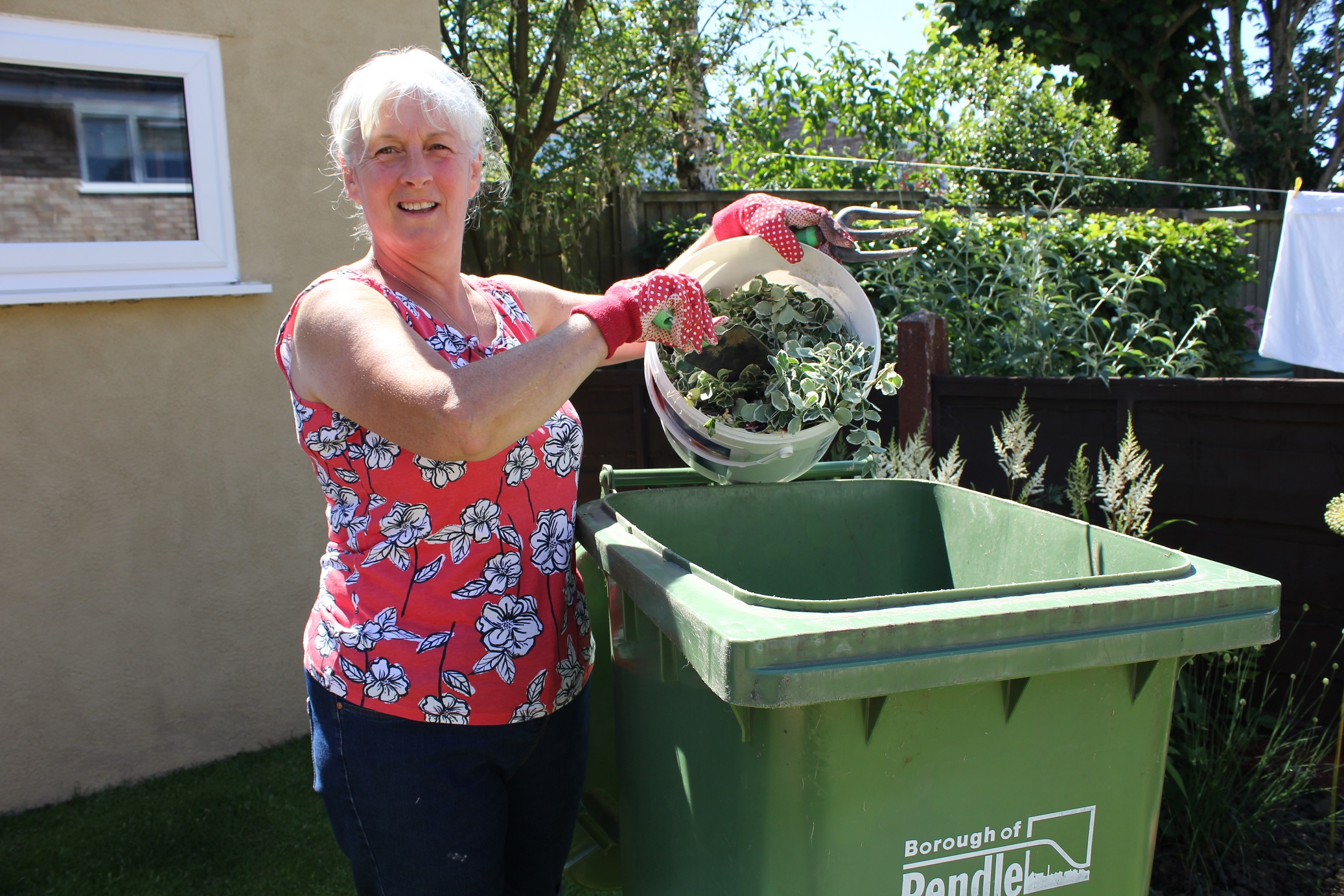 Photo of Pendle gardener with green garden waste bin.