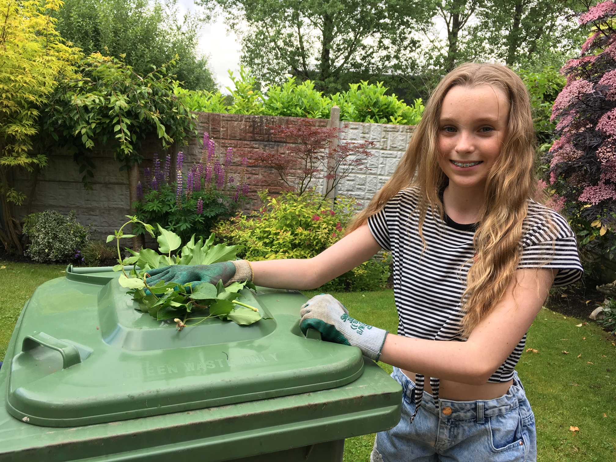 Young gardener with her green bin.